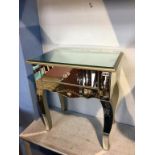 A mirrored glass side table