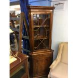 A reproduction mahogany corner cabinet