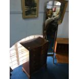 A reproduction mahogany serpentine fronted chest of drawers and a cheval mirror