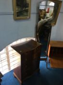 A reproduction mahogany serpentine fronted chest of drawers and a cheval mirror