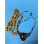 An amber coloured necklace and one other