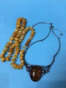 An amber coloured necklace and one other