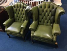A pair of green Chesterfield high back armchairs