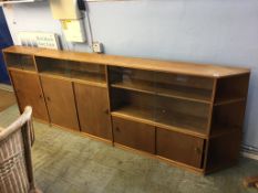 A long teak sliding door bookcase