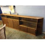 A long teak sliding door bookcase