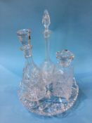 A glass circular plate and three decanters
