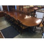 A reproduction mahogany triple pillar dining table, with three extra leaves and a set of 12