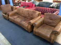 A brown leather three piece suite and foot stool