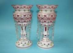 A pair of Victorian opaque glass lustres, flashed with cranberry and decorated with rose heads and