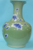 A very large Oriental vase, on a pale apple ground, decorated with blue and white flower heads