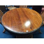 A 19th century rosewood circular tilt top table, with heavily carved frieze and base, supported on