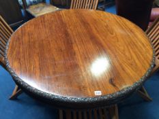 A 19th century rosewood circular tilt top table, with heavily carved frieze and base, supported on