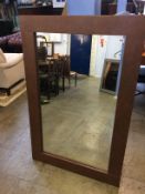 A brown leather edged mirror