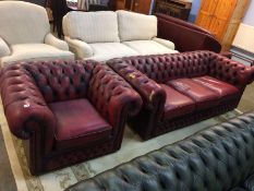 An oxblood Chesterfield Club armchair and three seater settee