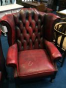 An oxblood leather wingback armchair