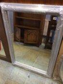 A silver ornate framed mirror