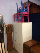 A modern wardrobe and three painted chairs