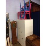 A modern wardrobe and three painted chairs