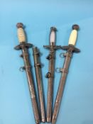 Three reproduction German daggers and a scabbard