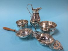 A silver jug, two tea strainers and a small bowl