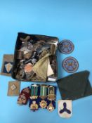 A collection of cap and shoulder badges and various patches etc.