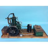 A live single cylinder petrol powered engine, with table saw, on a wooden stand. 28cm width x 77cm