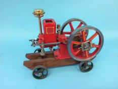 A hopper fed horizontal model engine, Amanco Waterloo Iowa, USA, on wood support with wheels. 34cm x