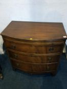 A mahogany bow front chest of drawers, with brushing slide