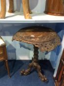 A heavily carved Eastern hardwood tripod table