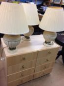 A pair of modern bedside chests and three lamps
