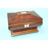 A small mahogany work box with fitted interior, waisted curving sides, supported on brass ball feet.