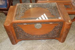 An Oriental carved chest and two low coffee tables