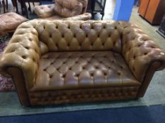 A two seater brown leather Chesterfield sofa