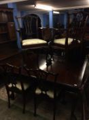 A mahogany extending dining table with two leaves and a set of eight chairs, comprising two