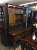 A small oak dresser with delft rack, below two short deep drawers, supported on cabriole legs, 136cm