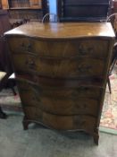 A reproduction mahogany serpentine front chest of drawers, with five long drawers and a brushing