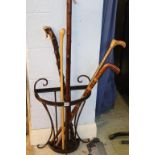 Various walking canes and sticks, with a stand