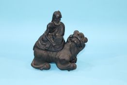 A stoneware censor of a Man seated on top of a dog of Fo, 23cm height x 20cm width approx.