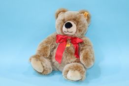 A modern brown Steiff teddy bear with red ribbon, number 018329