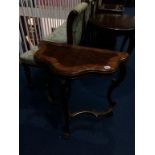 A shaped half moon decorative side table with crossbanded walnut top, supported on carved paw