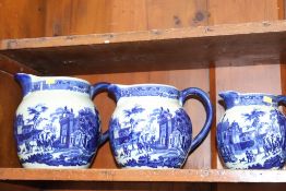 A set of five blue and white graduated jugs