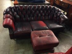 A Chesterfield oxblood three seater settee and footstool