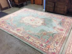 A large Chinese style green ground rug