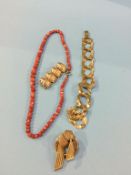 A coral necklace, a Ladybird brooch, another brooch and a bracelet