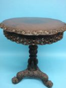 A 19th century heavily carved Burmese mahogany table with circular top, pierced and carved frieze,