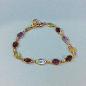 An 18ct gold bracelet, mounted with multi-coloured semi precious stones, 6.7g