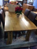A bespoke light oak dining table by Mark Talbot and six modern chairs