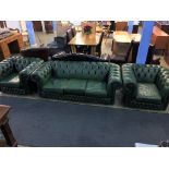 A green leather Chesterfield three seater settee and pair of armchairs