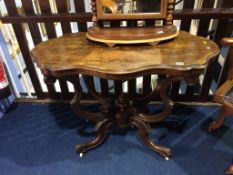 A Victorian walnut centre table with shaped and quarter top, below a shaped base