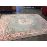 A large Chinese style green ground rug